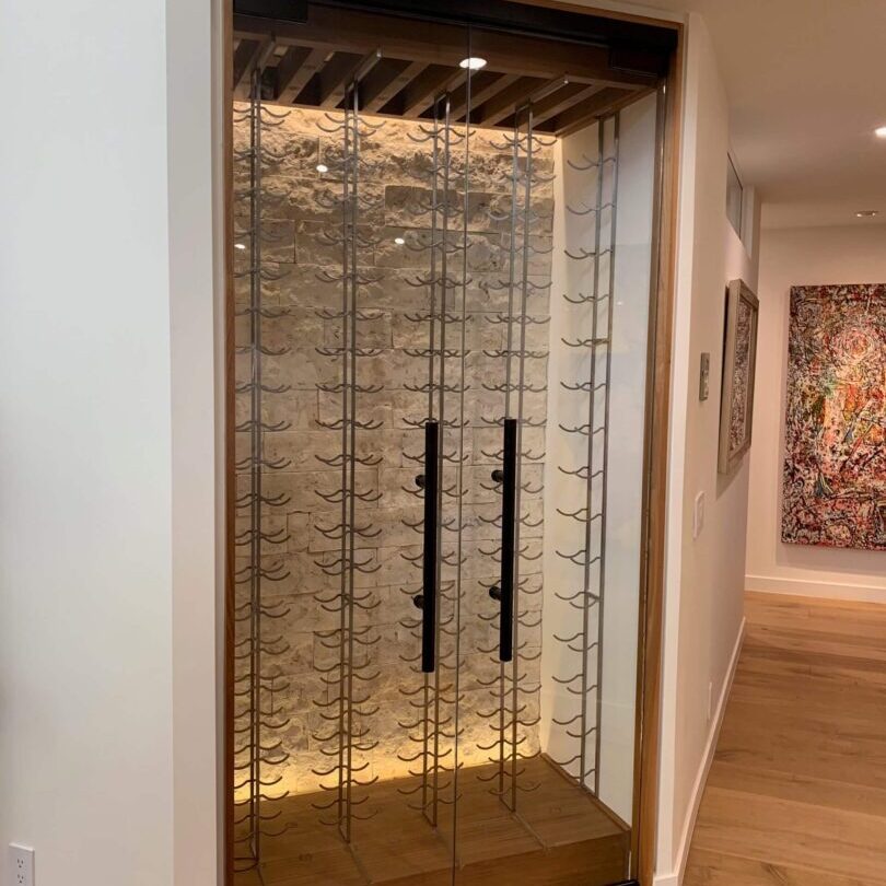 A wine cellar with glass doors in a home.